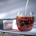 Is Earl Grey tea high in caffeine? A steaming cup of Earl Grey with bergamot and caffeine structure in the background.